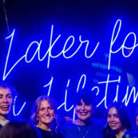 President Mantella smiles with a group of grads in front of the Laker for a Lifetime sign